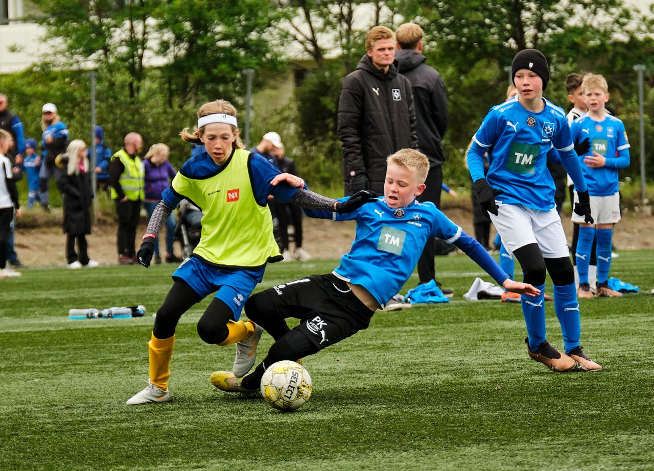 Saturday-morning grassroots football: kids and coaches on a club pitch